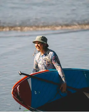 Joss Alabi saliendo del agua con su tabla de SUP