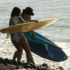Surfistas entrando al agua con sus tablas